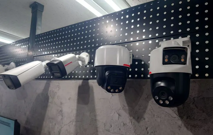名古屋オフィスの展示の壁の寄り。パンチングボードに筒形のカメラ2台と、白と黒のドーム型のカメラ2台が並ぶ