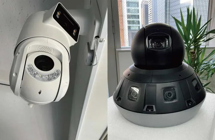 東京オフィスで展示しているカメラの寄り。壁に取り付けた白い大型のカメラ(左)と、複数のレンズを備えた黒いカメラ(右)